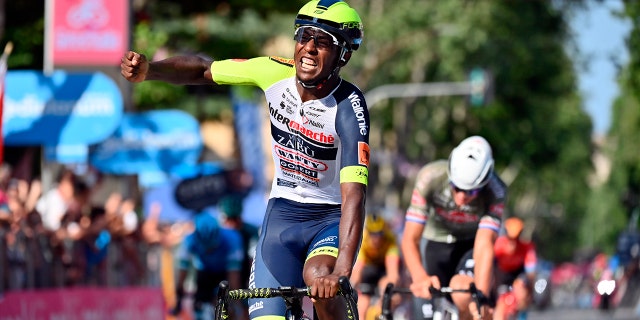 Eritrea's Biniam Girmay celebrates as he crosses the finish line of the 10th stage of the Giro D'Italia cycling race from Pescara to Jesi, Italy, Tuesday, May 17, 2022.
