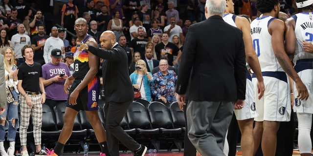 Bismack Biyombo of the Suns is escorted off the court during the final moments of Game Five of the Western Conference Second Round NBA Playoffs at Footprint Center on May 10, 2022, in Phoenix, Arizona.