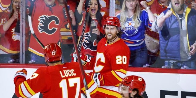 Calgary Flames forward Blake Coleman (20) celebrates his goal against the Edmonton Oilers with Milan Lucic (17) and Rasmus Andersson (4) during the second period of Game 1 of an NHL hockey second-round playoff series Wednesday, May 18, 2022, in Calgary, Alberta.