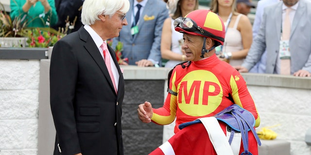 FILE - Jockey Mike Smith talks with trainer Bob Baffert after winning the Grade 2 Alysheba at Churchill Downs, Friday, May 3, 2019, in Louisville, Ky.
