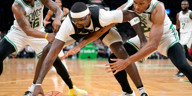Milwaukee Bucks center Bobby Portis, center, vies for control of the ball with Boston Celtics guard Marcus Smart, left, and center Al Horford, right, during the first half of Game 7 of an NBA basketball Eastern Conference semifinals playoff series, Sunday, May 15, 2022, in Boston.
