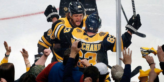 Boston Bruins' Brad Marchand (63) celebrates his goal with David Pastrnak during the second period of Game 3 of an NHL hockey Stanley Cup first-round playoff series against the Carolina Hurricanes, Friday, May 6, 2022, in Boston.