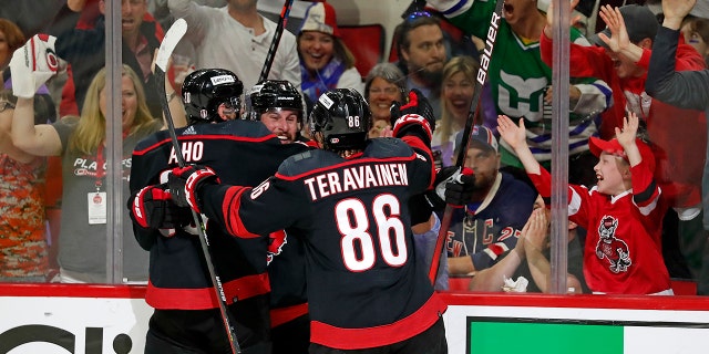 Brendan Smith của Carolina Hurricanes, ở giữa, ăn mừng bàn thắng của mình với các đồng đội Sebastian Aho (20) và Teuvo Teravainen (86) trong giai đoạn thứ hai của Trò chơi 2 của loạt playoff vòng hai khúc côn cầu NHL Stanley Cup tại Raleigh, N.C., Thứ Sáu, ngày 20 tháng 5 năm 2022.