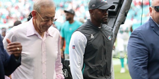Miami Dolphins head coach Brian Flores walks off the field with team owner Stephen Ross, left, after a loss to the Atlanta Falcons at Hard Rock Stadium on October 24, 2021 in Miami Gardens , fl.