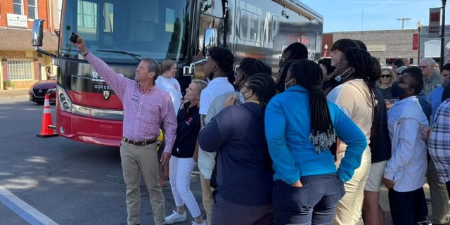 Georgia Gov. Brian Kemp takes a selfie with supporters, on the campaign trail in Blakely, Georgia on April 20, 2022