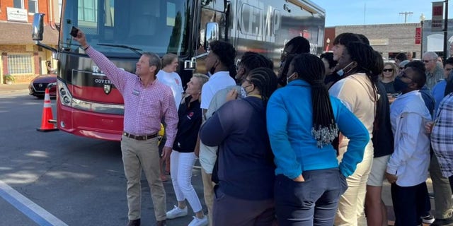 Georgia Gov. Brian Kemp takes a selfie with supporters on the campaign trail in Blakely, Georgia on April 20, 2022