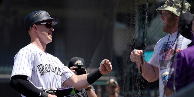 Colorado Rockies catcher Brian Serven is congratulated by a fan before making his major league debut against the San Francisco Giants, May 18, 2022, in Denver.