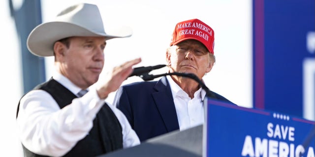 Republican gubernatorial candidate Charles Herbster speaks while former President Donald Trump stands by, at a rally in Greenwood, Nebraska, on May 1, 2022.