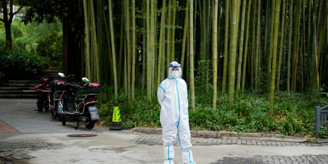 A woman in a protective suit stands on a street during lockdown, amid the coronavirus disease (COVID-19) pandemic, in Shanghai, China, May 26, 2022. 