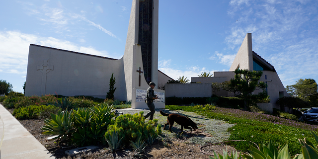 An Orange County Sheriff's Department K-9 unit checks the grounds at Geneva Presbyterian Church in Laguna Woods, Kalifornië, Sondag, Mei 15, 2022, after a fatal shooting. 