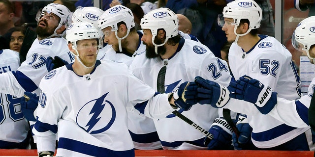 Tampa Bay Lightning right wing Corey Perry (10) celebrates a goal against the Florida Panthers with defenseman Zach Bogosian (24) and defenseman Cal Foote (52) during the second period of Game 1 of an NHL hockey second-round playoff series Tuesday, May 17, 2022, in Sunrise, Fla.