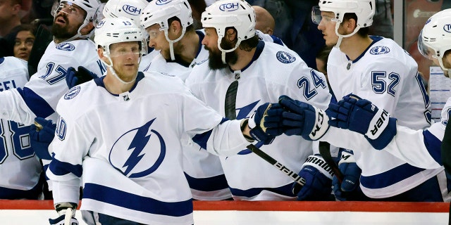 Tampa Bay Lightning right wing Corey Perry (10) celebrates a goal against the Florida Panthers with defenseman Zach Bogosian (24) and defenseman Cal Foote (52) during the second period of Game 1 of an NHL hockey second-round playoff series Tuesday, May 17, 2022, in Sunrise, Fla.