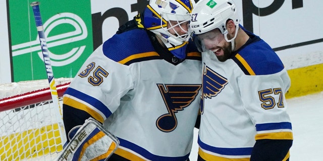 St. Louis Blues' David Perron, right, and St. Louis Blues goalie Ville Husso, celebrate after the Blues beat the Minnesota Wild 4-0 in Game 1 of an NHL hockey Stanley Cup first-round playoff series, Monday, May 2, 2022, in St. Paul, Minn. Perron scored three goals.