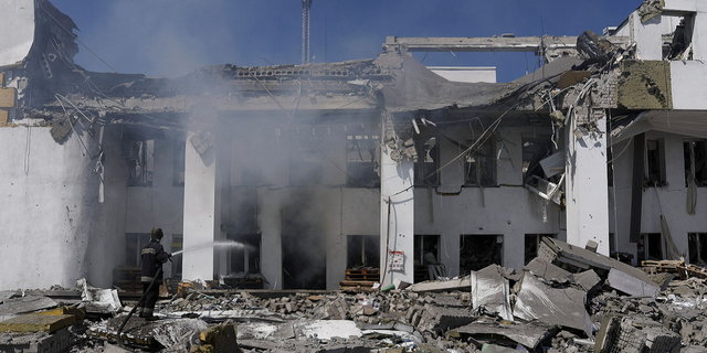 A firefighter works to extinguish a blaze after a Russian airstrike hit the House of Culture, which was used to distribute aid, in Derhachi, Ucraina, a Maggio 13.