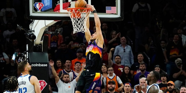 Phoenix Suns guard Devin Booker (1) dunks against Dallas Mavericks guard Jalen Brunson (13), Mavericks forwards Maxi Kleber (42) and Dorian Finney-Smith, derecho, during the first half of Game 5 of an NBA basketball second-round playoff series Tuesday, Mayo 10, 2022, en Phoenix.