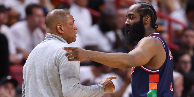 James Harden #1 of the Philadelphia 76ers talks with head coach Doc Rivers against the Miami Heat during the first half in Game Five of the Eastern Conference Semifinals at FTX Arena on May 10, 2022 in Miami, Florida.