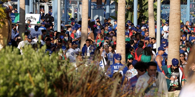 طرفداران لس آنجلس داجرز قبل از دومین بازی دو سر مقابل آریزونا دایموندبکز در استادیوم داجر در 17 می 2022 در لس آنجلس از دروازه عبور می کنند.