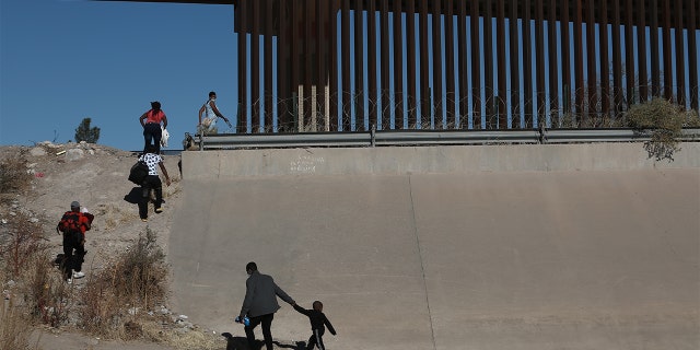 Haitian families crossing the Rio Bravo illegally to surrender at the border of Mexico's Ciudad Juarez with El Paso, Texas, in December 2021.