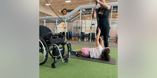 Elena, 15, is paralyzed and has "chemo brain" but she takes weight lifting classes with her mom twice a week. 