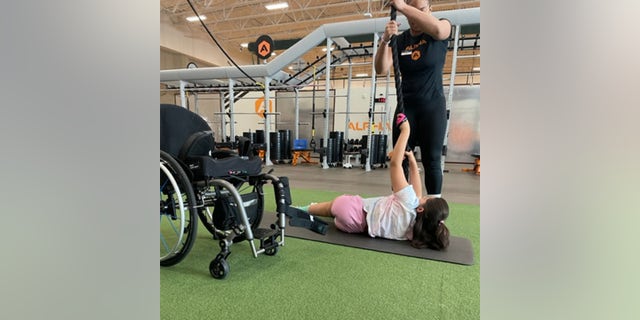 Elena, 15, is paralyzed and has "chemo brain" but she takes weight lifting classes with her mom twice a week.