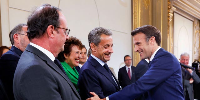 Former President Nicolas Sarkozy, center, shakes hands with French President Emmanuel Macron, right, during the ceremony of Macron's inauguration for a second term at the Elysee palace in Paris Saturday, May 7, 2022.