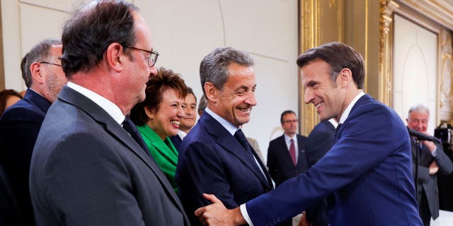 Former President Nicolas Sarkozy, center, shakes hands with French President Emmanuel Macron, right, during the ceremony of Macron's inauguration for a second term at the Elysee palace in Paris Saturday, May 7, 2022.