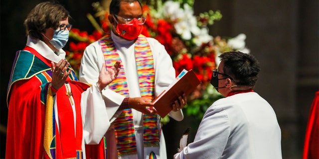 Bishop Elizabeth Eaton, left, speaks to Rev. Dr. Megan Rohrer, right, as they become the first openly transgender bishop of the Evangelical Lutheran Church in America on Sept. 11, 2021, in San Francisco.
