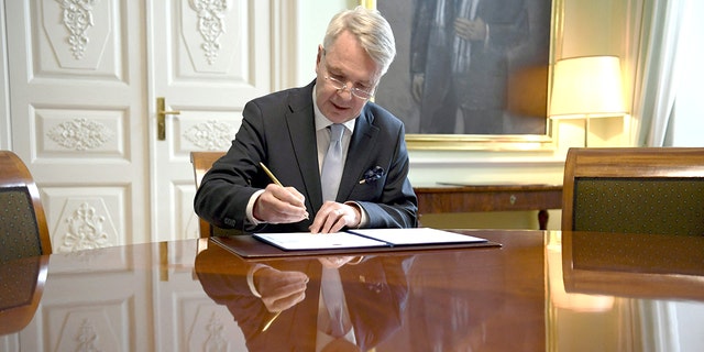 Finnish Foreign Minister Pekka Haavisto signs a petition for NATO membership in Helsinki on May 17, 2022.