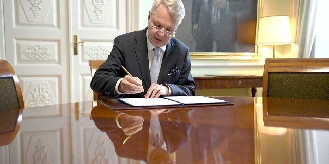 Finnish Foreign Minister Pekka Haavisto signs a petition for NATO membership in Helsinki on May 17, 2022.