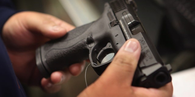 Un client achète un pistolet dans un magasin local.