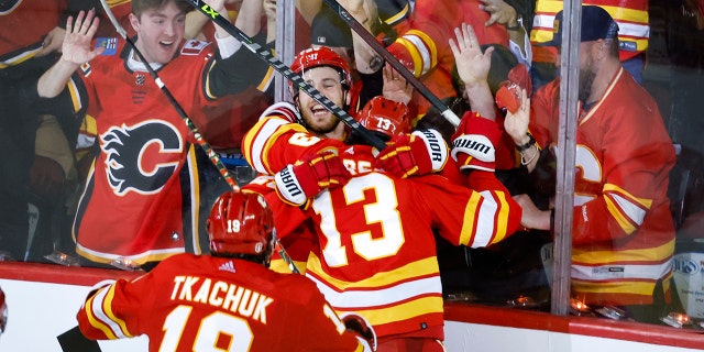 Calgary Flames forward Johnny Gaudreau, #13, celebrates his goal with teammates during overtime NHL playoff hockey action against the Dallas Stars in Calgary, Alberta, Sunday, May 15, 2022.
