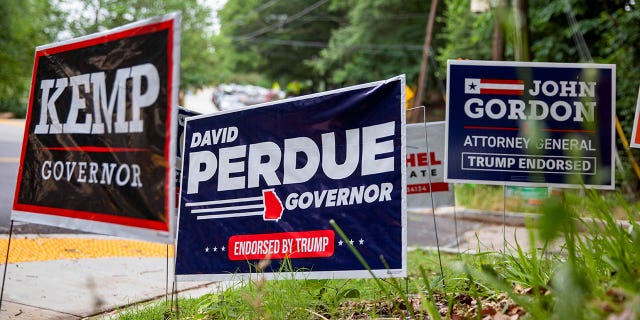 Campaign signs for Republican Georgia Gov. Brian Kemp and former Republican Georgia Sen. David Perdue on the side of the road.