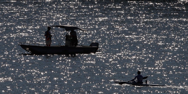 FILE - A kayaker paddles past a rescue boat during Day Four of the 2016 Canoe Kayak Pan American Championships at the Lake Lanier Olympic Venue on May 22, 2016, in Gainesville, Georgia. 