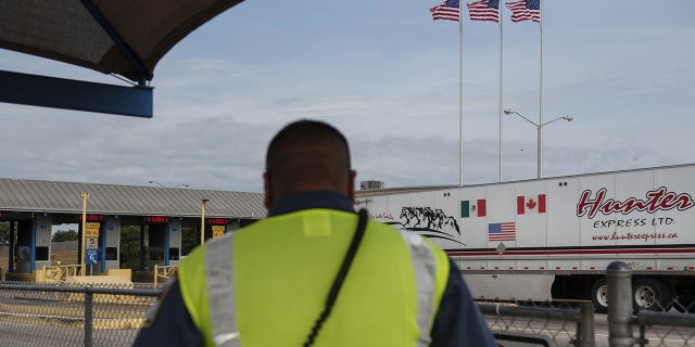 A security guard monitors trucks traveling across the World Trade International Bridge in Laredo, Texas, June 10, 2019.