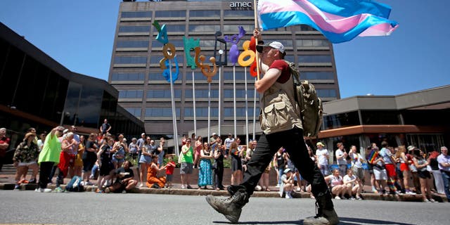 Athena Maxine holds a transgender pride flag during the annual Pride Portland! Parade in Portland, Maine, on June 15, 2019.