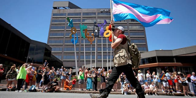 Athena Maxine holds a transgender pride flag during the annual Pride Portland! Parade in Portland, Maine, on June 15, 2019.