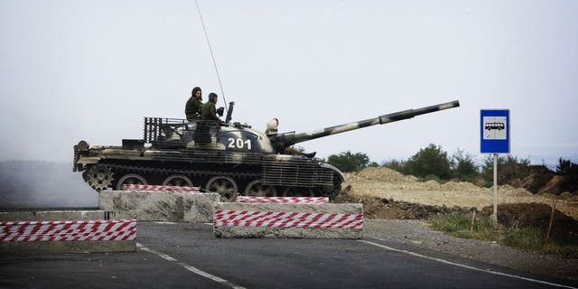 Ένα ρωσικό τανκ T62 διασχίζει τον άδειο αυτοκινητόδρομο που συνδέει την Τιφλίδα με τη δυτική Γεωργία στις 21 Αυγούστου 2008 σε ένα σημείο ελέγχου των ρωσικών δυνάμεων.  Η Ρωσία δεν σκοπεύει "κλείνοντας την πόρτα" Ο Ρώσος υπουργός Εξωτερικών Σεργκέι Λαβρόφ δήλωσε σήμερα ότι το ΝΑΤΟ θα πρέπει να επιλέξει τη συνεργασία με τη Μόσχα παρά τη στήριξη προς τη Γεωργία.  AFP PHOTO / MARCO LONGARI (Φωτογραφία Marco Longari/AFP) (Φωτογραφία Marco Longari/AFP μέσω Getty Images)