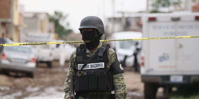 FILE - This photo shows a member of the Mexican National Guard standing outside a rehabilitation center attacked by armed assailants in Irapuato, Guanajuato, Mexico, July 1, 2020.