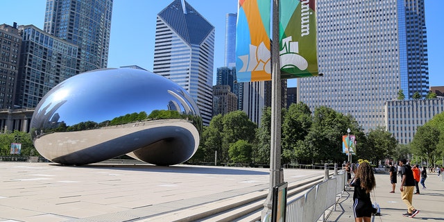 A person takes a photograph of the Cloud Gate sculpture, known as the Bean, at Millennium Park in Chicago July 24, 2020. 