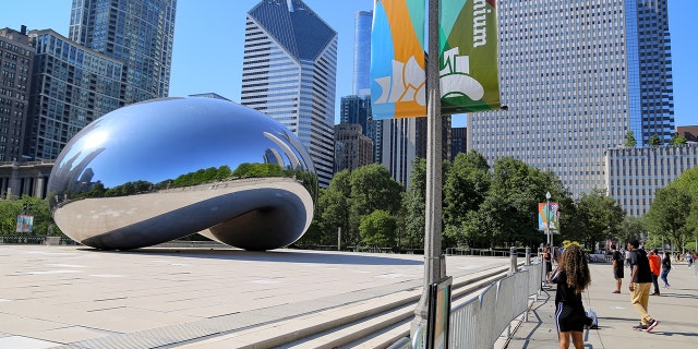 A person takes a photograph of the Cloud Gate sculpture, known as the Bean, at Millennium Park in Chicago July 24, 2020. 