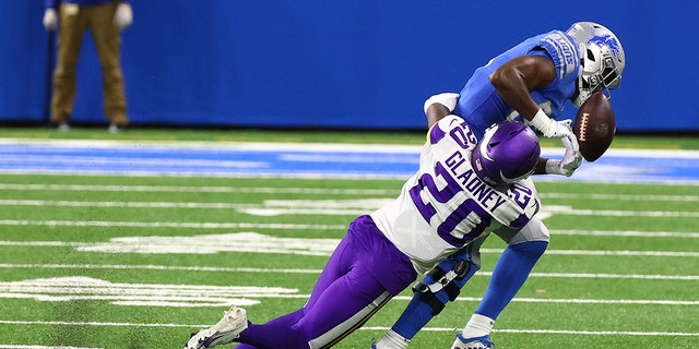 Kerry Johnson #33 of the Detroit Lions tries a catch against Jeff Gladney #20 of the Minnesota Vikings in the second quarter at Ford Field on January 3, 2021. 