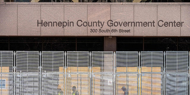 Workers install security fencing at the Hennepin County Government Headquarters in Minneapolis, Minnesota, on March 3, 2021. (Photo by Kerem Yucel / AFP) (Photo by KEREM YUCEL/AFP via Getty Images)