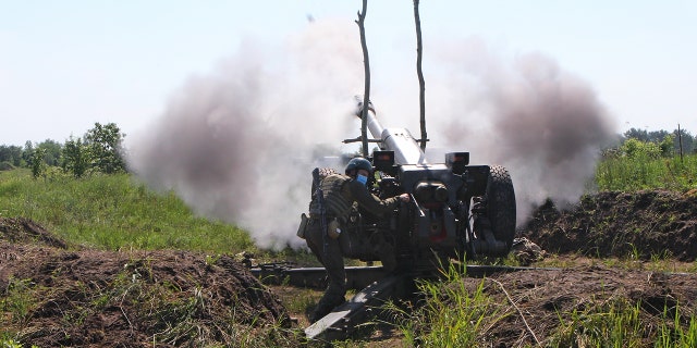 KHARKIV REGION, UKRAINE - JUNE 14, 2021 - A soldier fires a howitzer gun sight during an artillery training at the Eastern Operational Region Command of the Ukrainian National Guard, Kharkiv region, northeastern Ukraine. 