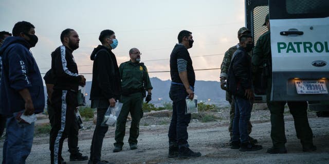 Migrants caught crossing the US-Mexico border are loaded into a transport van by US Border Patrol agents in Sunland Park, New Mexico.