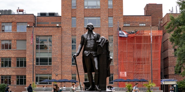 Students walk past a statue of George Washington on campus at George Washington University in Washington, D.C., U.S., on Thursday, Sept. 9, 2021. Photographer: Stefani Reynolds/Bloomberg via Getty Images