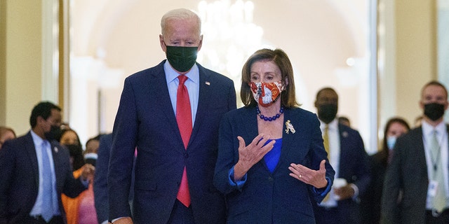 US President Joe Biden walks with Speaker of the House Nancy Pelosi as he departs the US Capitol after a caucus meeting in Washington, corriente continua, en octubre 1, 2021.