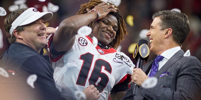 Georgia Bulldogs DB Lewis Cine (16) célèbre avec l'entraîneur-chef des Georgia Bulldogs Kirby Smart et l'hôte ESPN Rece Davis après l'Alabama Crimson Tide contre les Georgia Bulldogs dans le championnat national des éliminatoires de football universitaire, le 10 janvier 2022, au Lucas Oil Stadium à Indianapolis , DANS. 