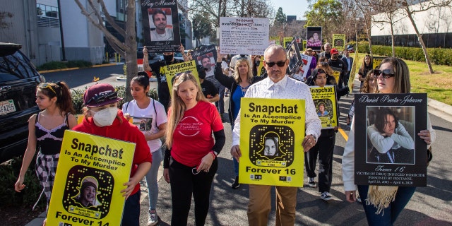Amy Neville (3rd L) and Jaime Puerta (2nd R) whose children died from fentanyl poisoning protest against illicit drug availability to children on the app Snapchat near the Snap, Inc. headquarters, in Santa Monica, California on January 21, 2022.