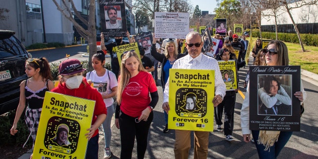 Amy Neville (3rd L) and Jaime Puerta (2nd R) whose children died from fentanyl poisoning protest against illicit drug availability to children on the app Snapchat near the Snap, Inc. headquarters, in Santa Monica, California on January 21, 2022. 