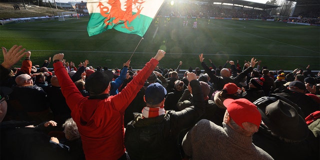 Supporters celebrate Wrexham Association Football Club's first goal during a National League fixture football match against Maidenhead United, at the Racecourse Ground stadium, in Wrexham, north Wales, 在一月 29, 2022.